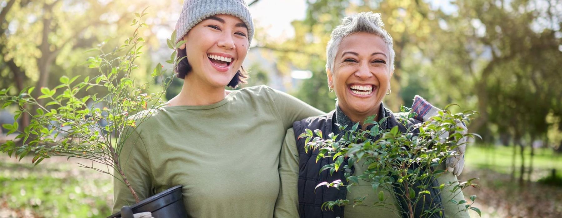 a couple of women holding plants